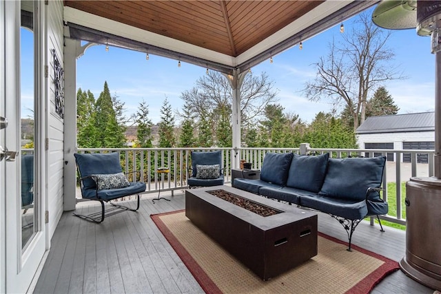 deck featuring an outdoor living space with a fire pit