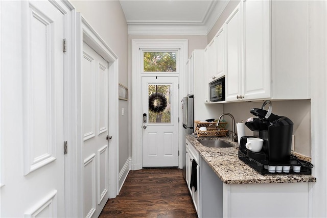 kitchen with white cabinetry, black microwave, sink, dark hardwood / wood-style floors, and light stone counters