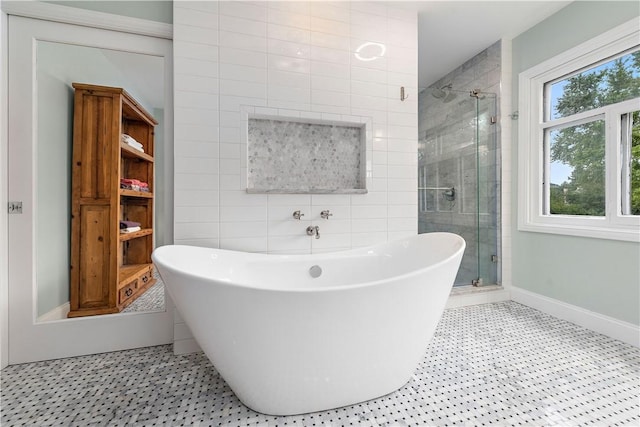 bathroom featuring a healthy amount of sunlight, tile walls, and independent shower and bath