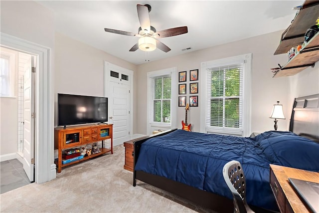 carpeted bedroom featuring ceiling fan and ensuite bath