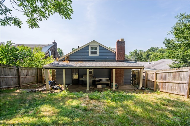 back of property featuring a patio area and a yard