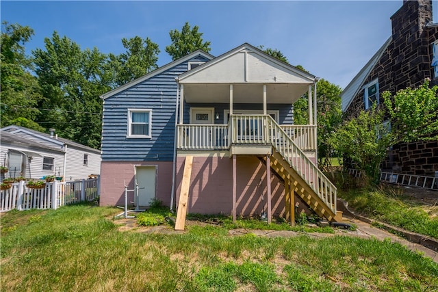 rear view of house featuring a yard