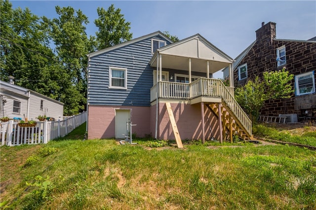 rear view of property with central AC and a lawn