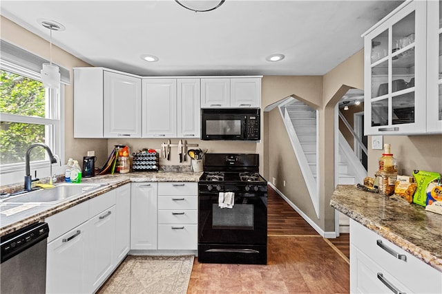 kitchen featuring hanging light fixtures, sink, black appliances, and white cabinetry