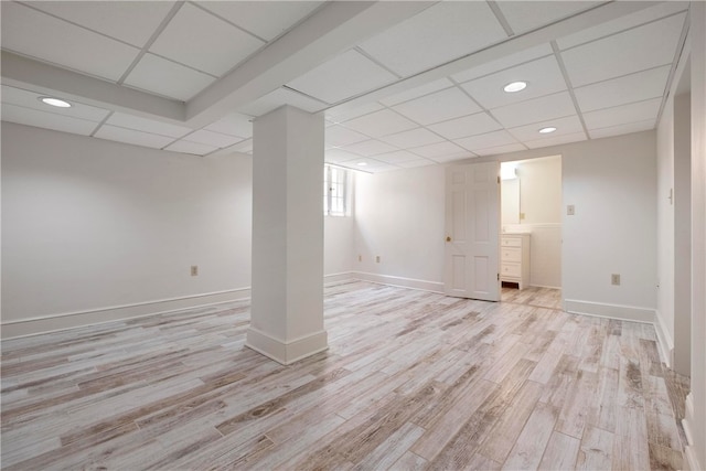 basement with light hardwood / wood-style flooring and a drop ceiling