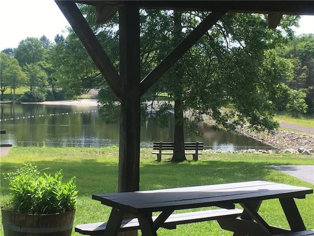 view of community with a water view and a yard