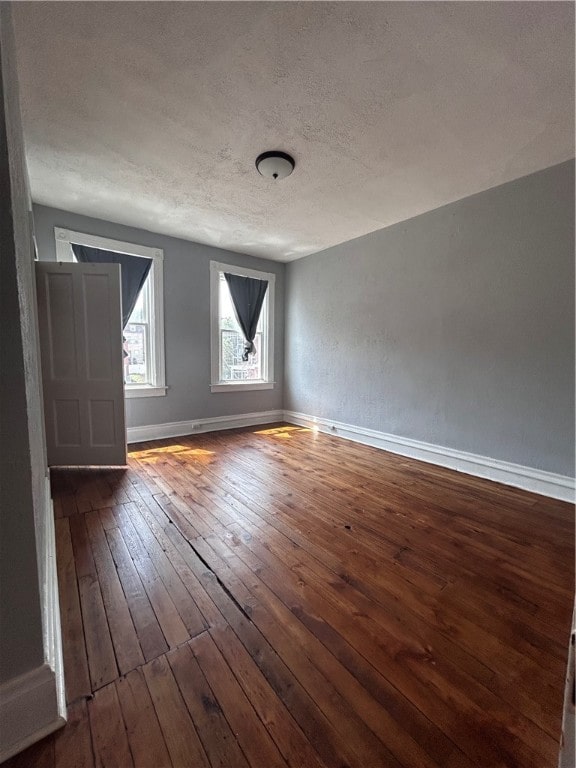 bonus room featuring dark wood-type flooring and a textured ceiling