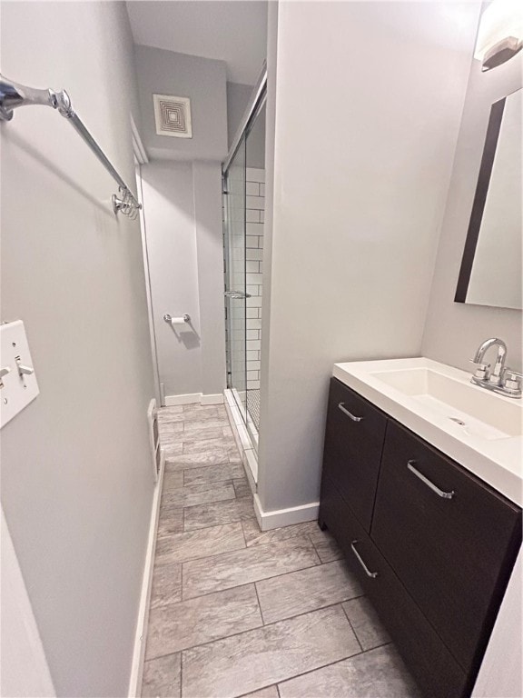 bathroom featuring tile patterned flooring, a shower with door, and vanity