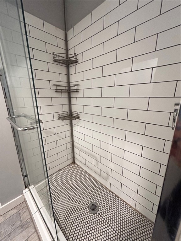 bathroom featuring hardwood / wood-style flooring and a shower with door