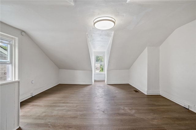 bonus room with dark wood-type flooring and vaulted ceiling