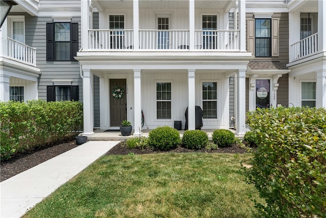 property entrance featuring a balcony and a yard