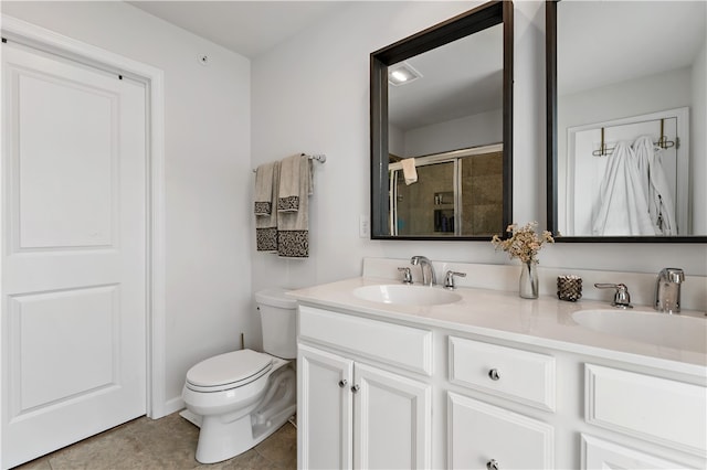 bathroom with tile patterned floors, double sink vanity, and toilet