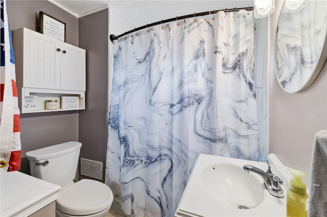 bathroom featuring vanity, ornamental molding, a textured ceiling, and toilet