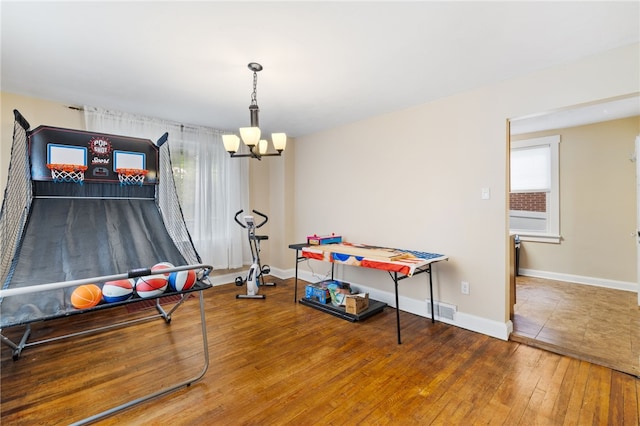 rec room featuring an inviting chandelier and wood-type flooring