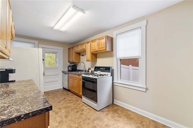 kitchen with white refrigerator, dishwasher, sink, and range with gas cooktop