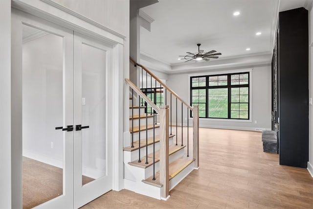 stairs with crown molding, french doors, ceiling fan, and wood-type flooring