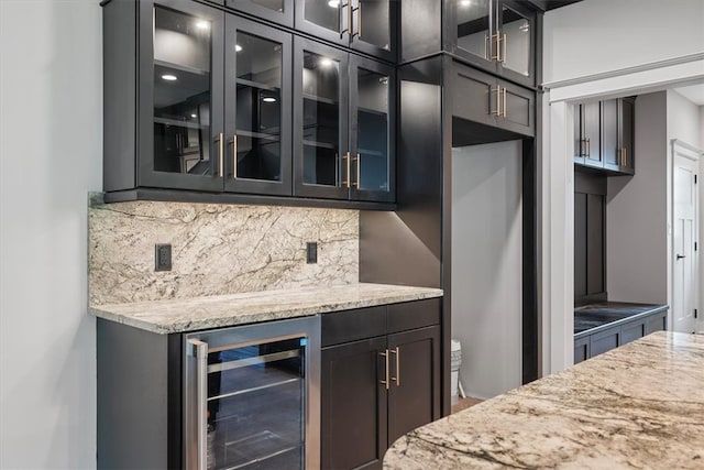 kitchen with decorative backsplash, light stone counters, and beverage cooler