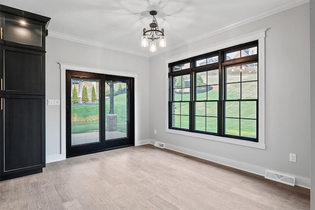 doorway featuring crown molding, light hardwood / wood-style floors, and an inviting chandelier