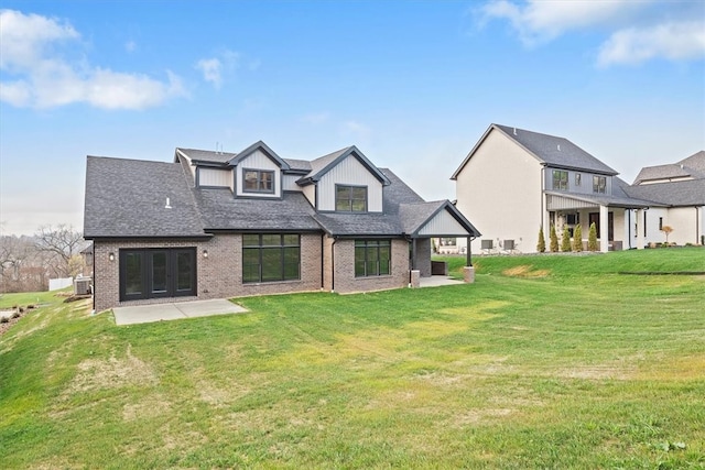 rear view of house featuring a lawn and a patio