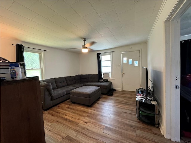 living room featuring ceiling fan, cooling unit, and light hardwood / wood-style flooring