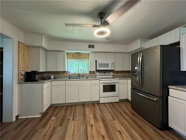 kitchen with hardwood / wood-style floors, white cabinetry, white appliances, and sink