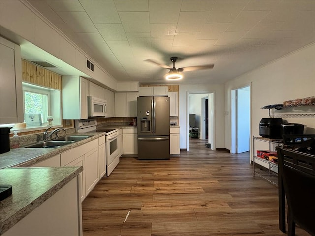 kitchen with hardwood / wood-style floors, white appliances, sink, ceiling fan, and white cabinetry