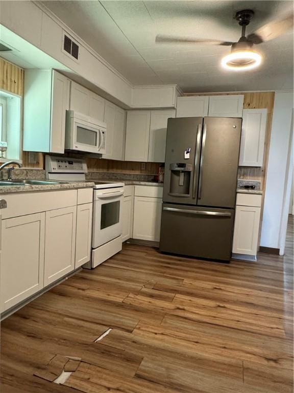 kitchen with white cabinetry, sink, dark hardwood / wood-style floors, and white appliances