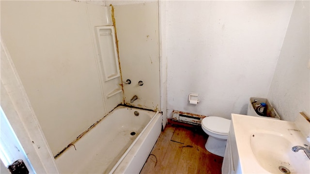 full bathroom with shower / tub combination, a baseboard heating unit, toilet, vanity, and hardwood / wood-style floors