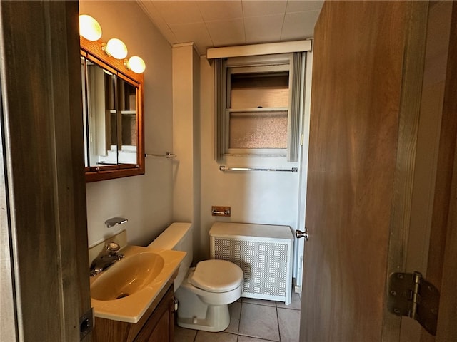 bathroom featuring tile patterned floors, toilet, vanity, and radiator heating unit