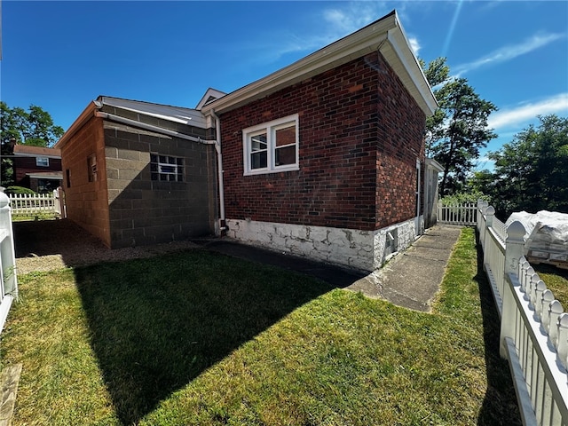 view of side of home with a lawn