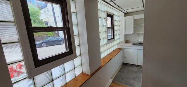 interior space with a paneled ceiling and sink