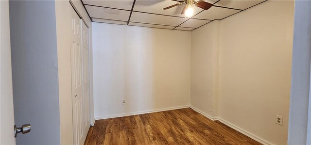 unfurnished room with a paneled ceiling, hardwood / wood-style flooring, and ceiling fan