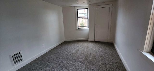 carpeted empty room with a paneled ceiling