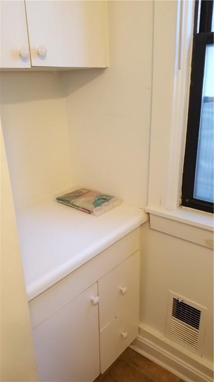 laundry area featuring dark tile patterned flooring