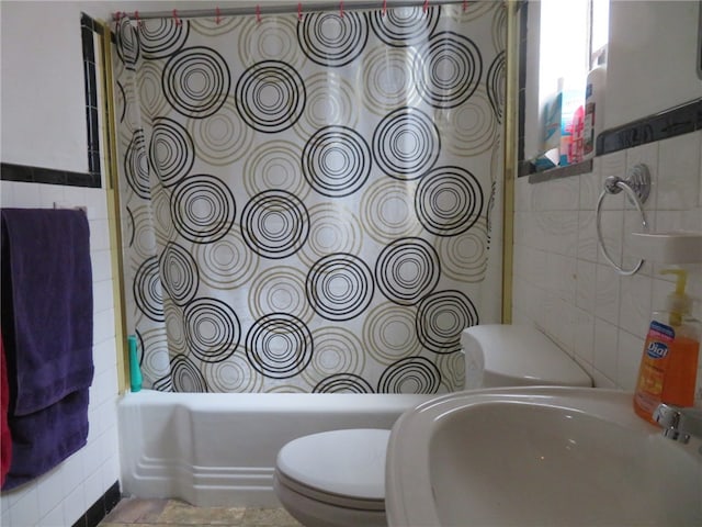 full bathroom with sink, tile walls, tiled shower / bath combo, and toilet