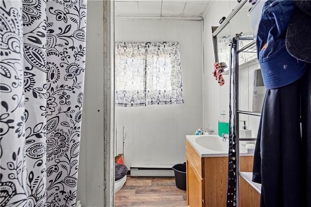 bathroom featuring a baseboard radiator, hardwood / wood-style floors, vanity, toilet, and a shower with shower curtain