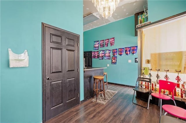 rec room with dark hardwood / wood-style floors and a chandelier