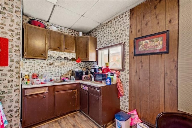 kitchen featuring a paneled ceiling and light hardwood / wood-style flooring