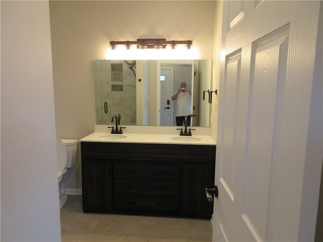 bathroom featuring toilet, tile patterned flooring, and double vanity