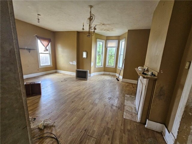 interior space with a notable chandelier, a textured ceiling, and hardwood / wood-style flooring