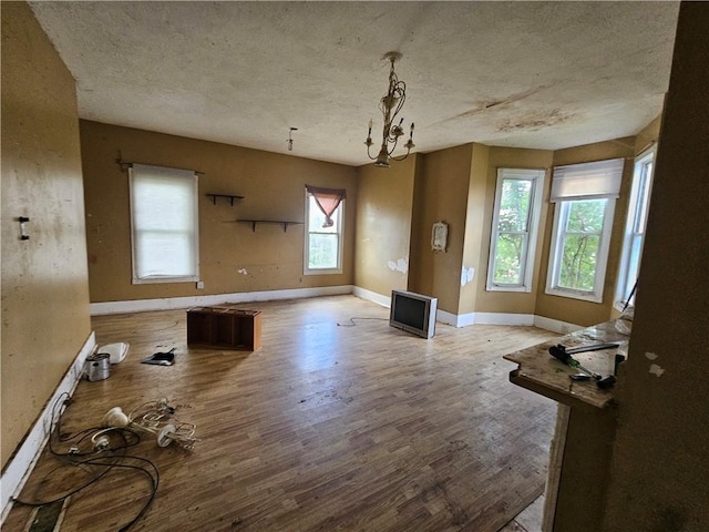 unfurnished dining area with light hardwood / wood-style floors and a textured ceiling