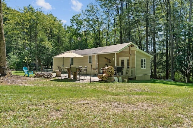 rear view of property with a yard, french doors, and a patio