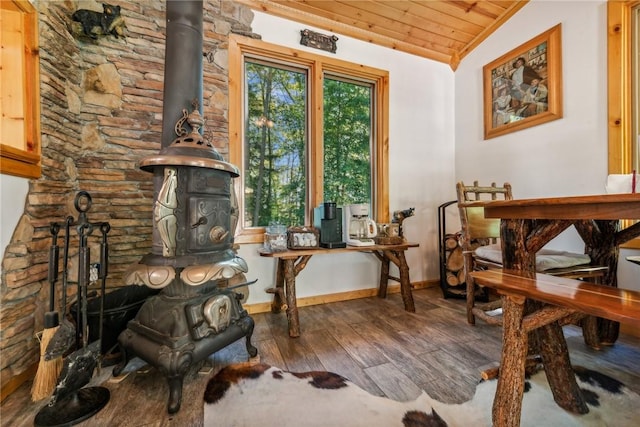 sitting room with a wood stove, hardwood / wood-style floors, wood ceiling, and vaulted ceiling