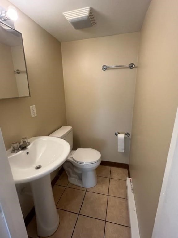 bathroom with tile patterned floors, toilet, and a baseboard radiator