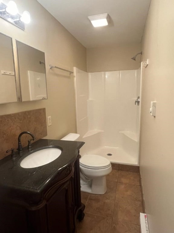 bathroom featuring vanity, toilet, tile patterned floors, and walk in shower