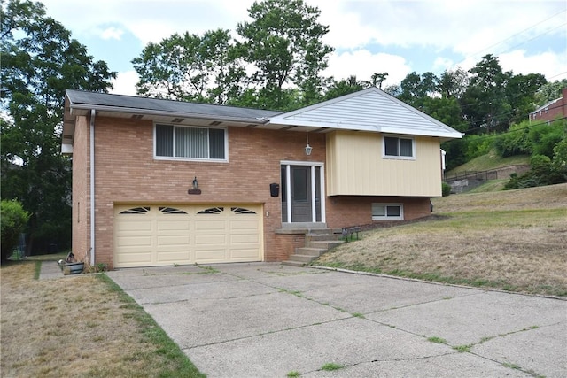 split foyer home featuring a garage and a front lawn