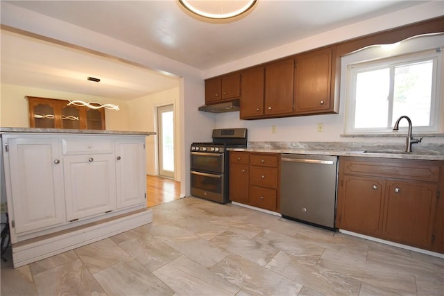 kitchen featuring stainless steel appliances, hanging light fixtures, and sink