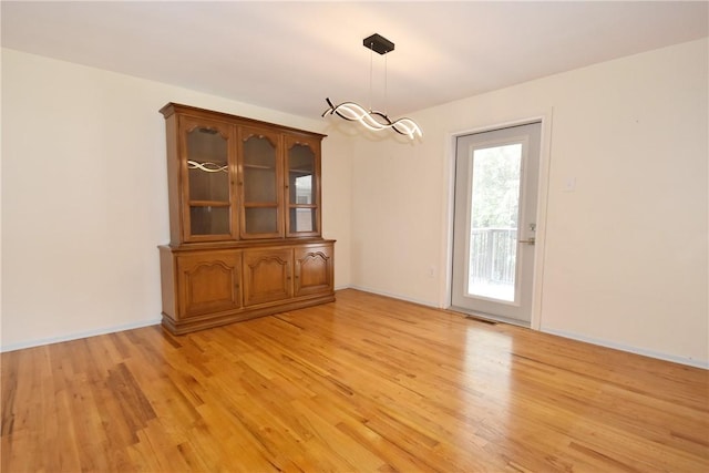 unfurnished dining area featuring light wood-type flooring