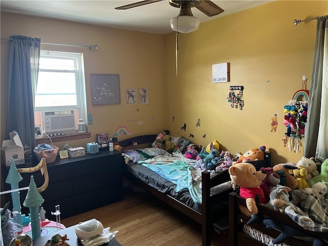 bedroom featuring wood-type flooring, ceiling fan, and cooling unit