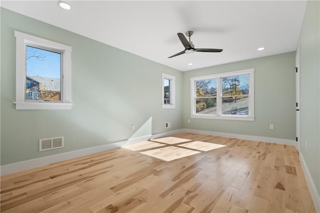 unfurnished room featuring light hardwood / wood-style floors, ceiling fan, and a healthy amount of sunlight